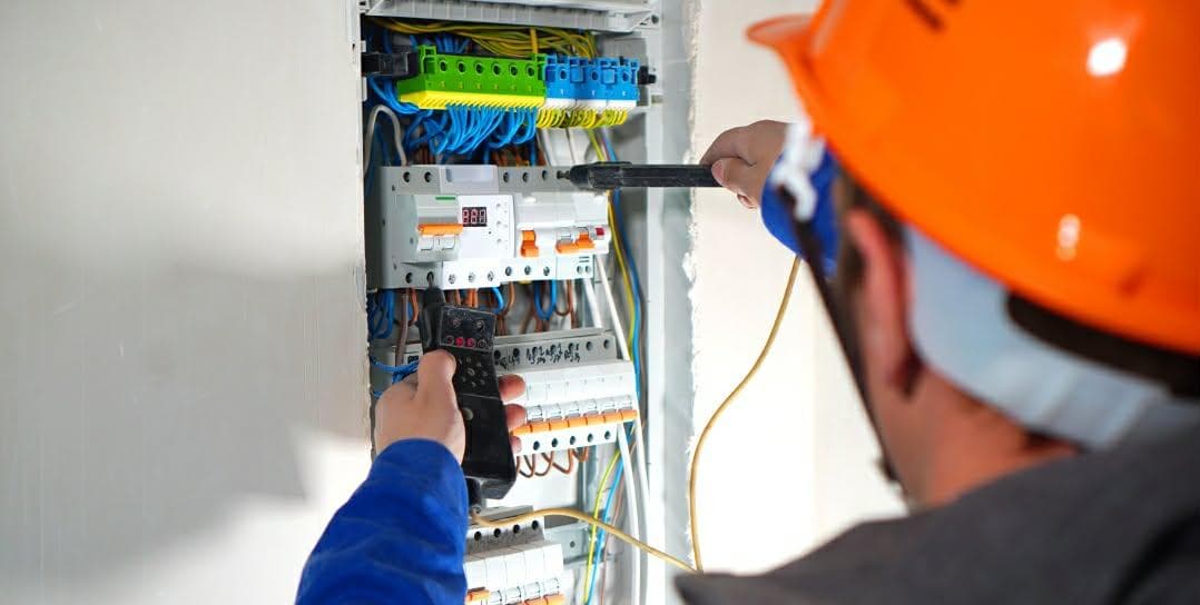 Électricien intervenant sur un tableau électrique pour une mise aux normes à Cholet